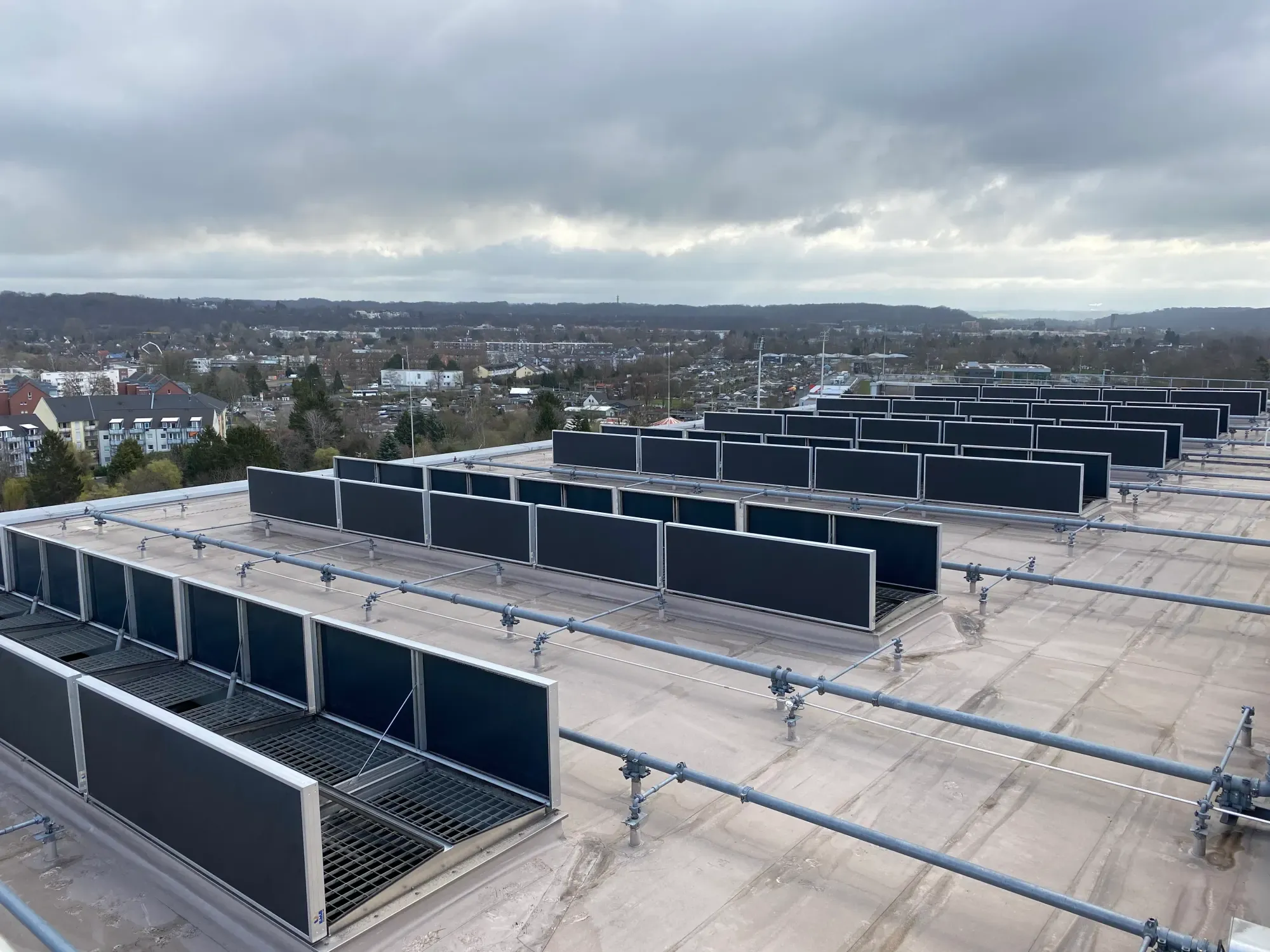 Blick über ein Industriedach mit geöffneten Rauch- und Wärmeabzugsanlagen, betreut von Röther-Interservice in NRW