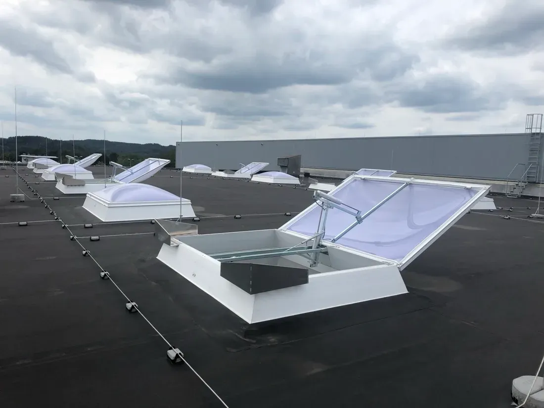 Lichtkuppeln mit geöffnetem Rauch- und Wärmeabzug auf einem Industriedach in NRW